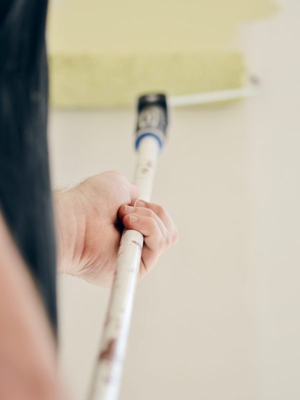 photo-of-a-man-painting-the-wall-with-paint-in-lig-WXRHY5G