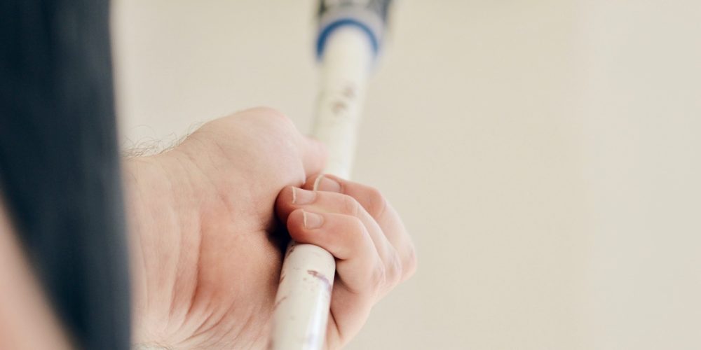 photo-of-a-man-painting-the-wall-with-paint-in-lig-WXRHY5G